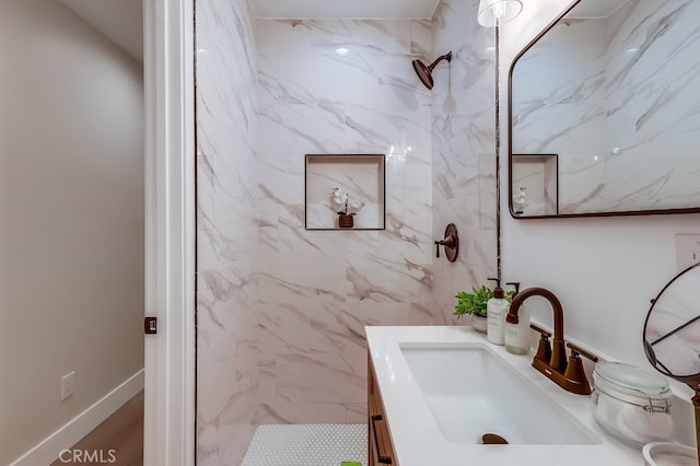 bathroom featuring a marble finish shower and vanity