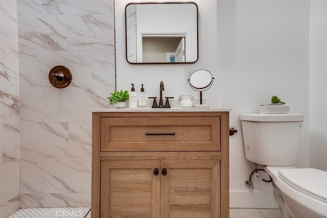 bathroom featuring toilet, vanity, and a tile shower