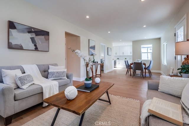 living room featuring recessed lighting, light wood-type flooring, and baseboards