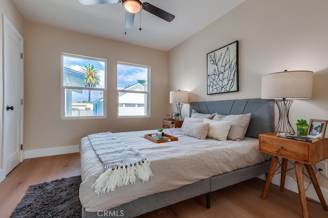bedroom featuring a ceiling fan, wood finished floors, and baseboards