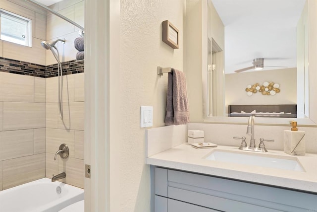 bathroom with shower / bathing tub combination, a textured wall, and vanity
