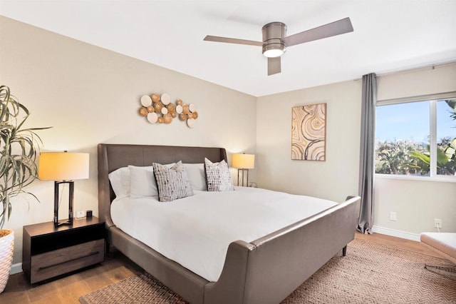bedroom with wood finished floors, baseboards, and ceiling fan