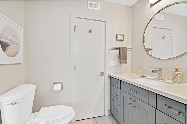 bathroom with visible vents, toilet, and vanity