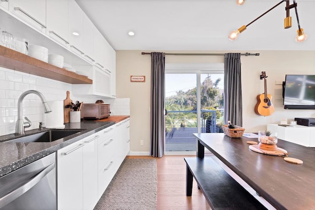 kitchen featuring a sink, tasteful backsplash, light wood-style floors, open shelves, and dishwasher