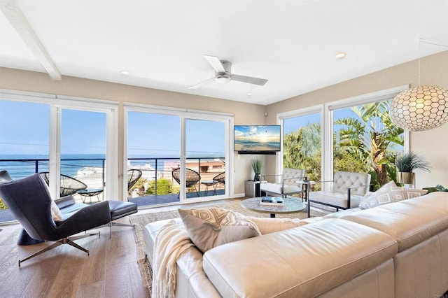 living area with a ceiling fan, wood finished floors, recessed lighting, and a water view