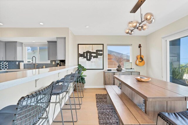 1631 Neptune Ave, Encinitas, CA 92024 - dining space with light wood-style floors, plenty of natural light, a chandelier, baseboards, and recessed lighting