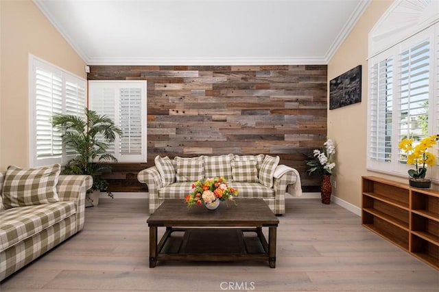 living area featuring wooden walls, baseboards, ornamental molding, and wood finished floors