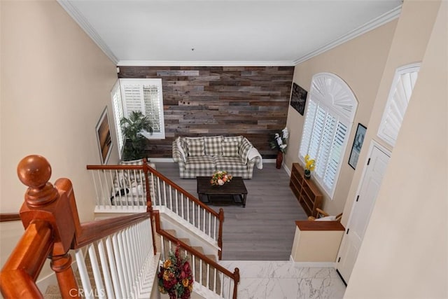 staircase with marble finish floor, an accent wall, baseboards, and ornamental molding
