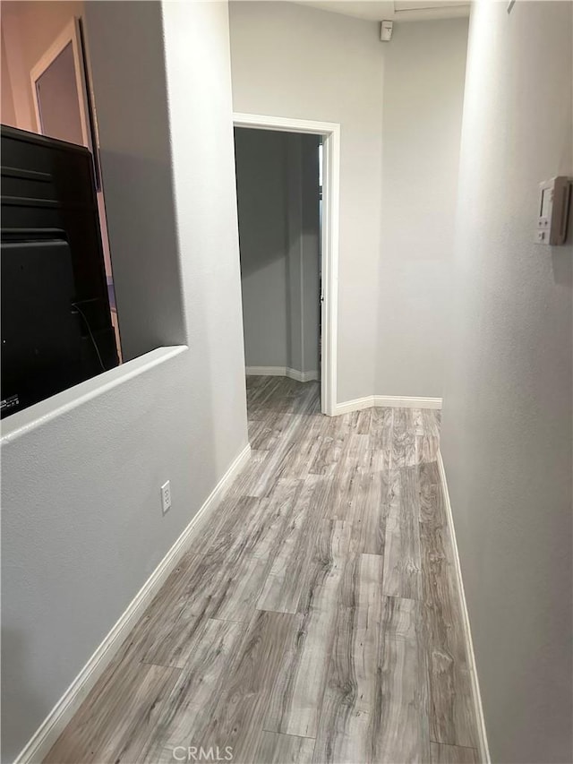 hall with baseboards and wood finished floors
