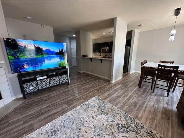 living area featuring recessed lighting, baseboards, and wood finished floors