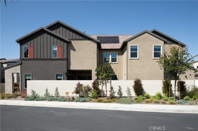 135 Bosal, Irvine, CA 92618 - view of property exterior with board and batten siding and roof mounted solar panels