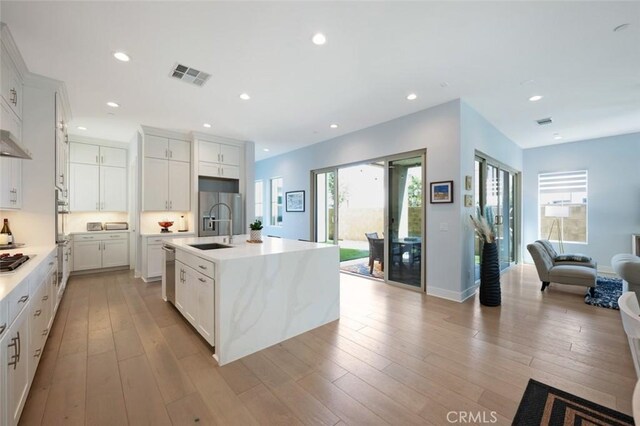 135 Bosal, Irvine, CA 92618 - kitchen with open floor plan, a sink, light countertops, light wood finished floors, and recessed lighting