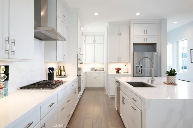 135 Bosal, Irvine, CA 92618 - kitchen featuring wall chimney exhaust hood, a sink, stainless steel appliances, white cabinetry, and recessed lighting