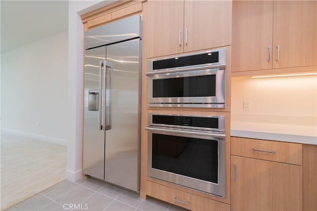 1406 Rivington, Irvine, CA 92612 - kitchen featuring light brown cabinetry, stainless steel appliances, light countertops, light tile patterned floors, and baseboards