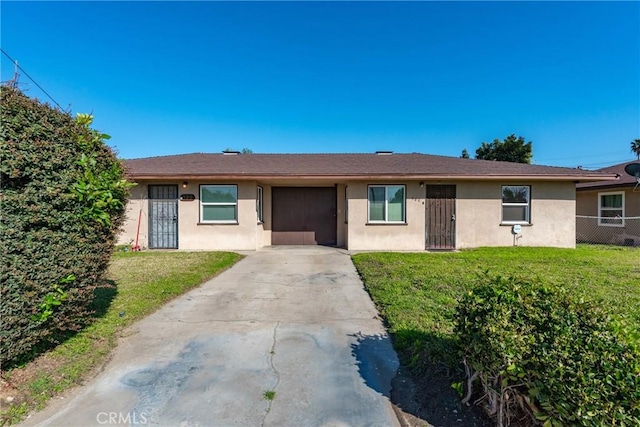 single story home with fence, an attached garage, stucco siding, a front lawn, and concrete driveway