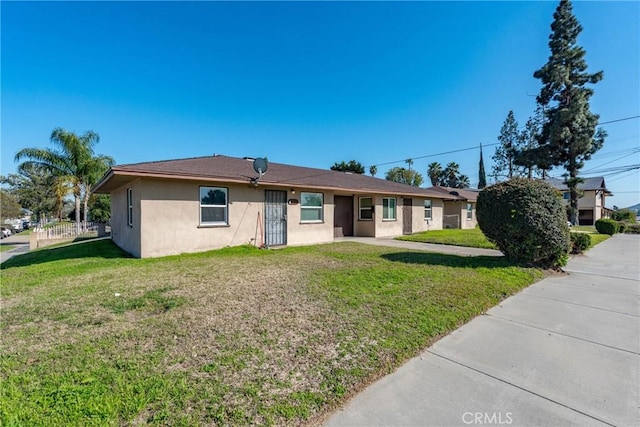 single story home featuring stucco siding and a front yard