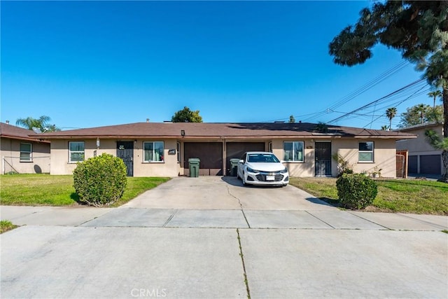 single story home featuring stucco siding, an attached garage, concrete driveway, and a front yard