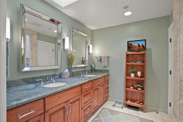 full bathroom featuring double vanity, visible vents, baseboards, and a sink