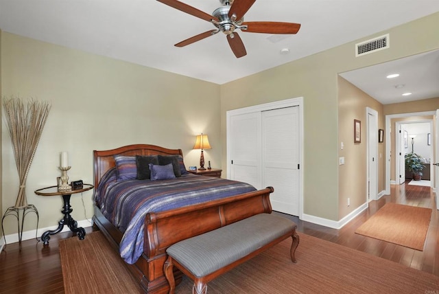 bedroom with visible vents, baseboards, a closet, and wood finished floors