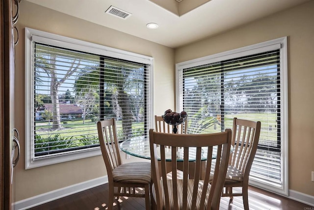 dining space featuring visible vents, a healthy amount of sunlight, baseboards, and wood finished floors