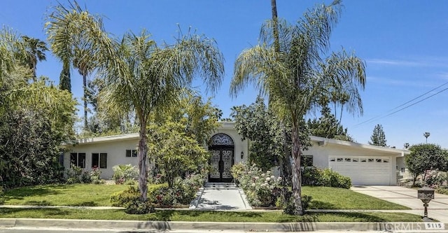5115 Boda Pl, Woodland Hills, CA 91367 - view of property hidden behind natural elements with stucco siding, a garage, and a front lawn