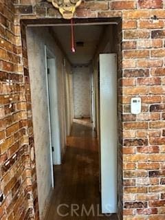 corridor featuring brick wall