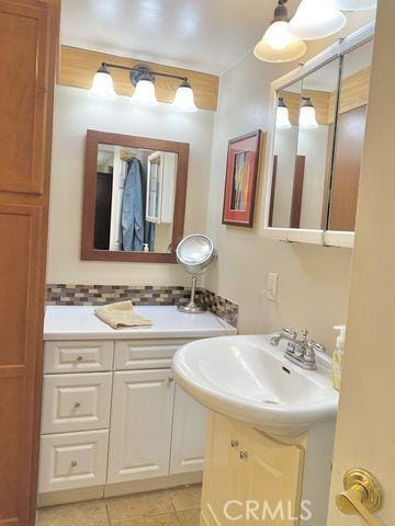 bathroom with tile patterned flooring, backsplash, and vanity
