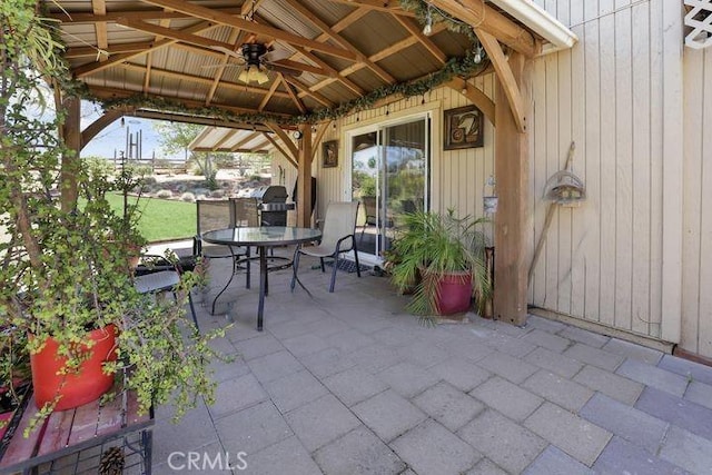 view of patio with a gazebo, outdoor dining area, and ceiling fan