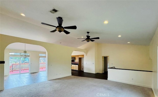 carpeted empty room with a ceiling fan, visible vents, lofted ceiling, recessed lighting, and arched walkways