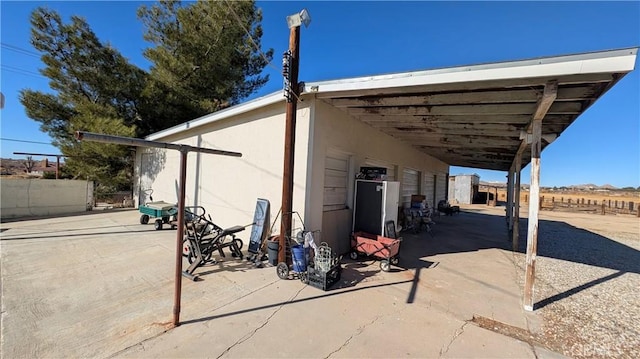 view of patio / terrace with an attached carport and fence