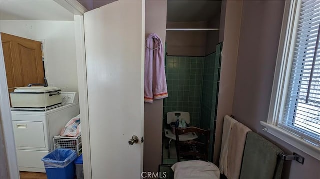 full bath with washer / clothes dryer and a stall shower