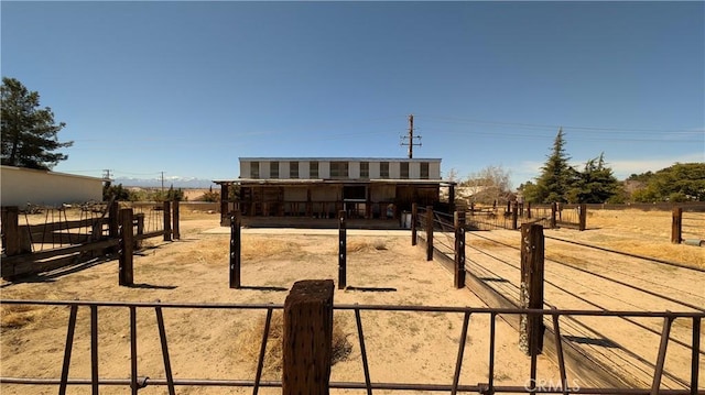 view of front of home with an outdoor structure, an exterior structure, and a rural view