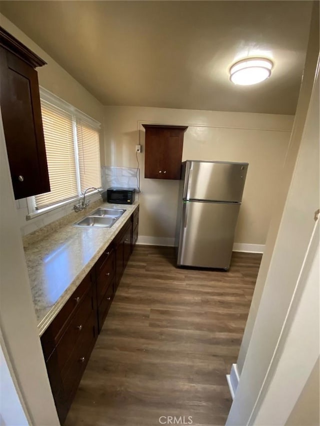 3030 W 12th Pl, Los Angeles, CA 90006 - kitchen with a sink, freestanding refrigerator, black microwave, light countertops, and dark wood-type flooring