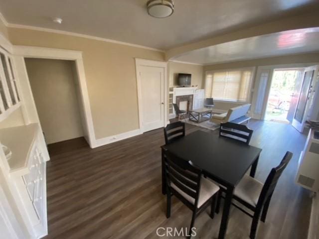 3030 W 12th Pl, Los Angeles, CA 90006 - dining space featuring baseboards, ornamental molding, dark wood-type flooring, and a fireplace