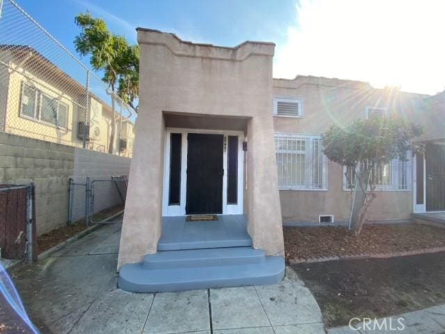 3030 W 12th Pl, Los Angeles, CA 90006 - property entrance featuring fence, crawl space, and stucco siding