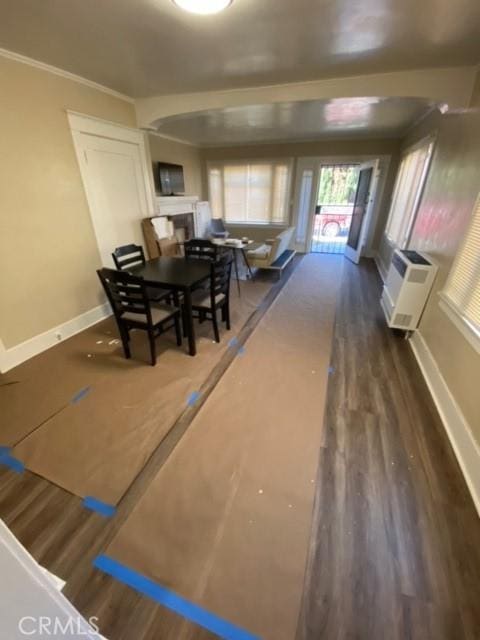 3030 W 12th Pl, Los Angeles, CA 90006 - dining room featuring a wall mounted air conditioner, wood finished floors, crown molding, baseboards, and a fireplace