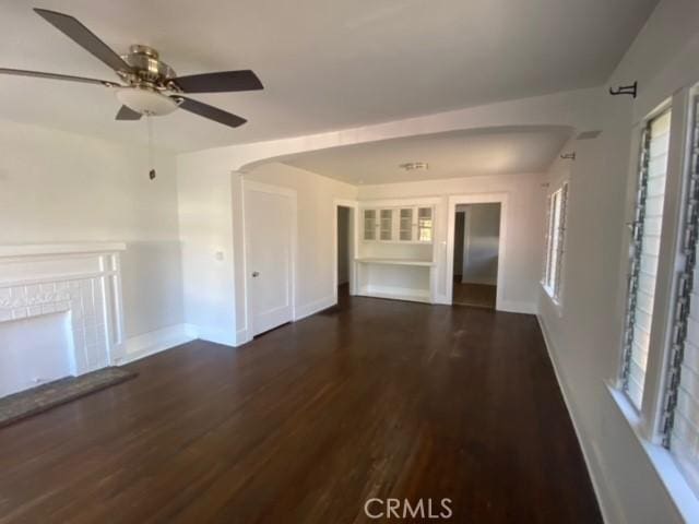 3030 W 12th Pl, Los Angeles, CA 90006 - unfurnished living room with wood finished floors, a fireplace with raised hearth, a ceiling fan, and baseboards