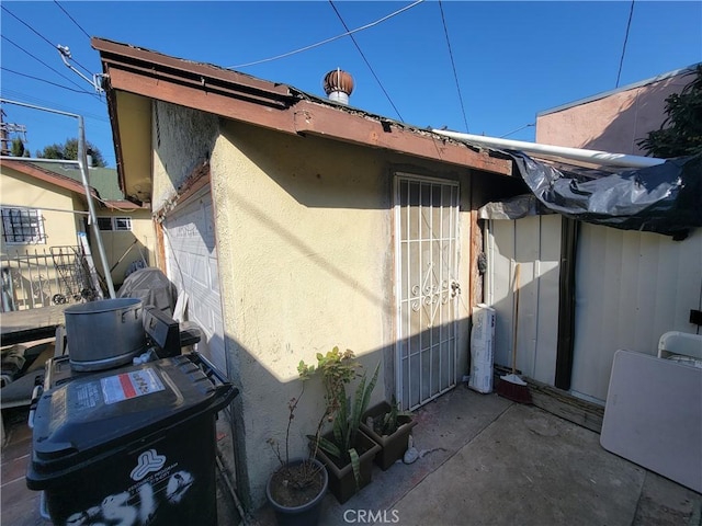 5510 S San Pedro St, Los Angeles, CA 90011 - view of property exterior with stucco siding, a garage, and fence
