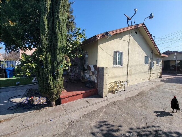 5510 S San Pedro St, Los Angeles, CA 90011 - view of home's exterior featuring stucco siding and fence