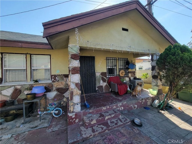 5510 S San Pedro St, Los Angeles, CA 90011 - rear view of property featuring a patio, stone siding, and stucco siding