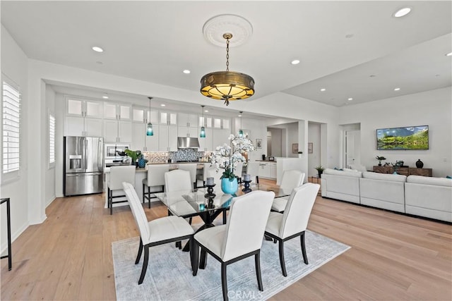 dining room with baseboards, light wood-style flooring, and recessed lighting