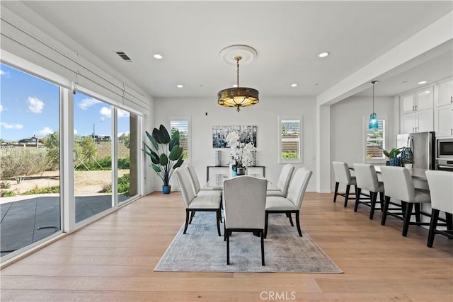 dining room featuring light wood finished floors, a wealth of natural light, and recessed lighting