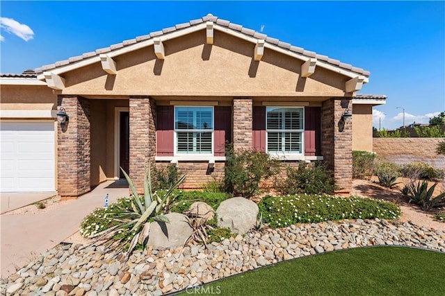 view of front of home featuring an attached garage, stone siding, concrete driveway, stucco siding, and a tiled roof