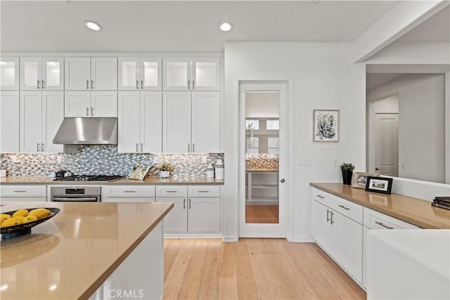 kitchen featuring under cabinet range hood, light wood-style floors, white cabinets, and appliances with stainless steel finishes