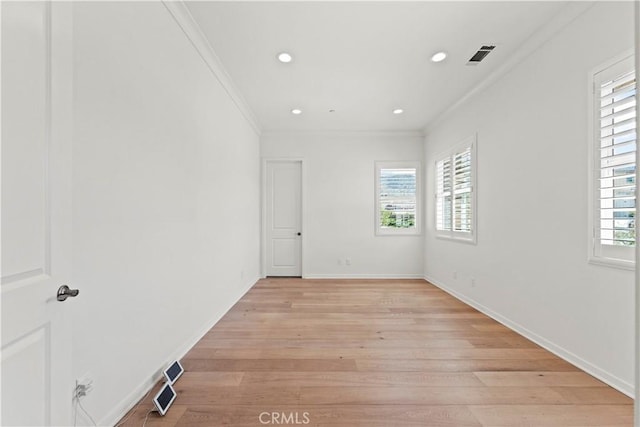 empty room with light wood-type flooring, visible vents, ornamental molding, and recessed lighting