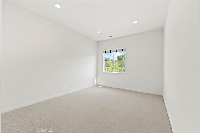 empty room with light carpet, baseboards, and recessed lighting