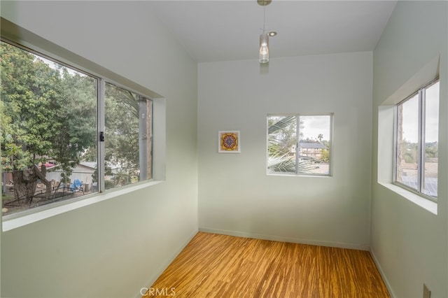 spare room with wood finished floors and baseboards