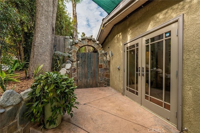 view of patio / terrace with a gate, french doors, and fence
