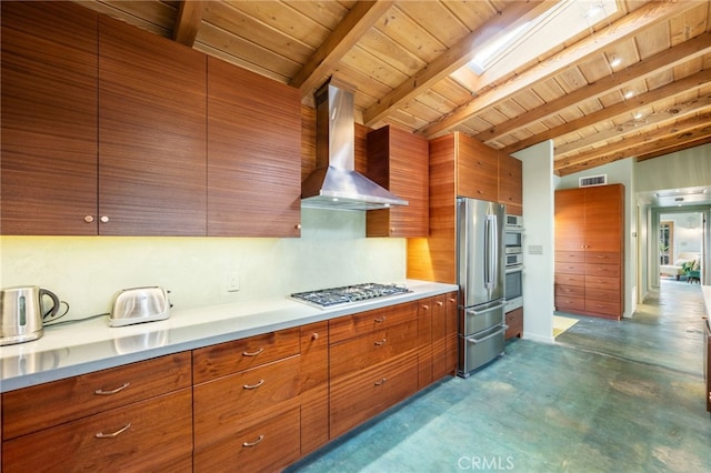 kitchen featuring brown cabinetry, visible vents, stainless steel appliances, and wall chimney exhaust hood