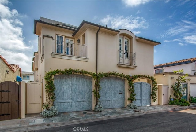 129 Via Waziers, Newport Beach, CA 92663 - view of front of property featuring a balcony, a gate, stucco siding, and an attached garage